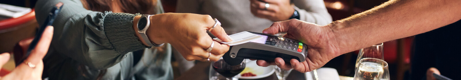 person holding out a credit card to a payment processor 